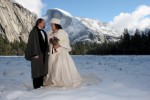 Bride and groom in snow covered meadow with a view of snow capped half doom. winter wedding in yosemite national park