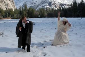 Bride and groom snowball fight. fun wedding photo in a snow covered meadow winter wedding in yosemite national park