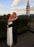 Bride and groom embrase, evening light, clock tower, Wedding ceremony rooftop garden Hotel Vitale San Francisco CA