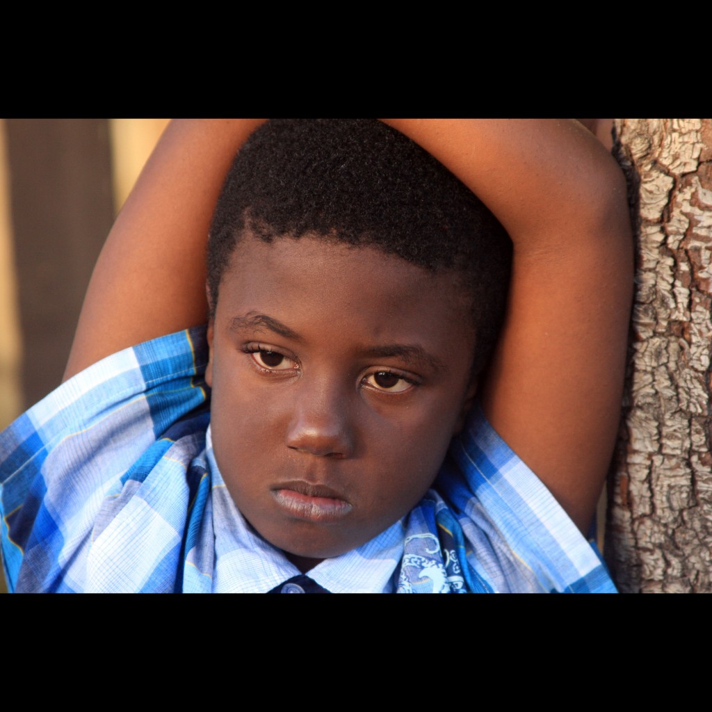 Moody portrait of a black school boy.