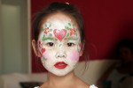 Intense and pretty Korean child in face paint at a party